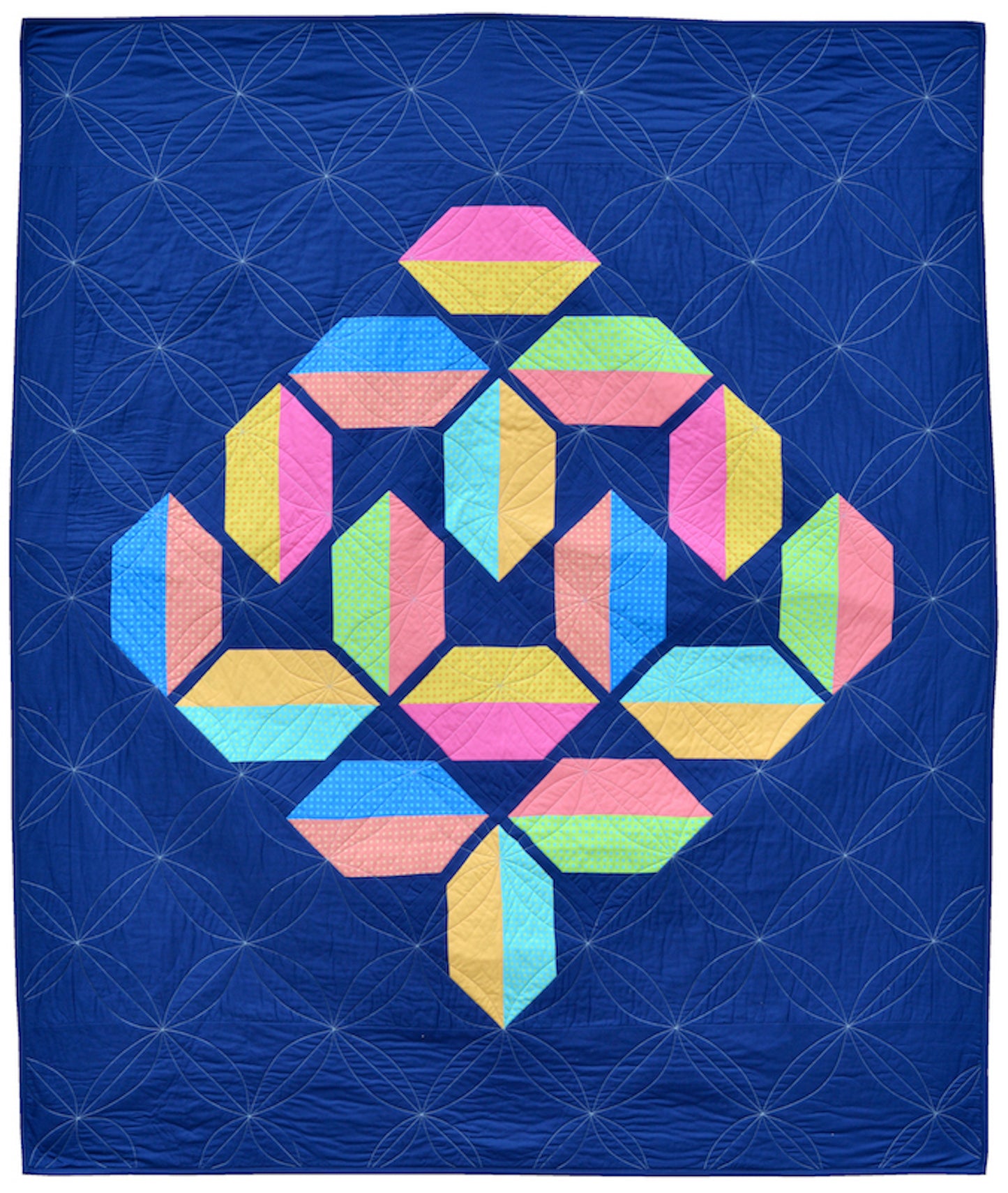 Flourishing quilt pattern in scrappy colours pink, peach, yellow, blue, green and lime on a navy blue background