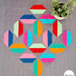 Flourishing quilt in scrappy colours, red, blue, orange, green and pink on a grey background